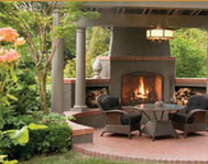 A patio with a fireplace and wicker furniture.