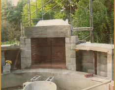 A concrete fireplace being built in a yard.