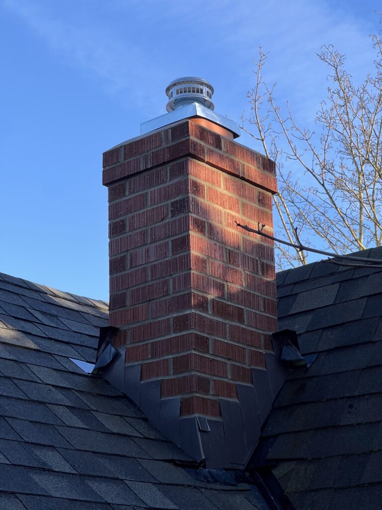 A brick chimney with a metal cap