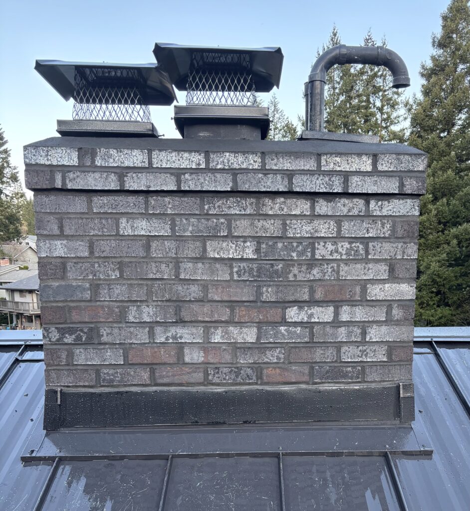 A brick chimney with a metal cap